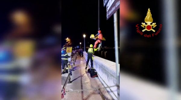 Scivola nel fiume Adige e si aggrappa a masso per non essere travolta